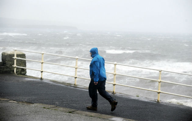 Un hombre ante el fuerte oleaje en la costa del Condado de Clare, Irlanda. Foto. EFE.