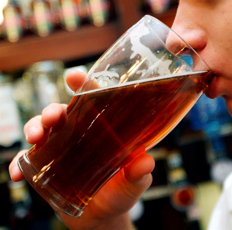 Una mujer bebe una cerveza. Foto: EFE