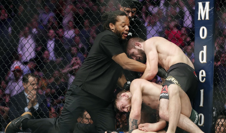 Khabib Nurmagomedov somete a  Conor McGregor (c) ante la mirada del árbitro Herb Dean (izq.). /Foto AP