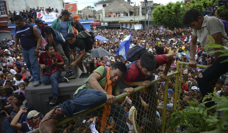 Desafiando la presencia policial un grupo de migrantes pasa la frontera hacia Guatemala. EFE 