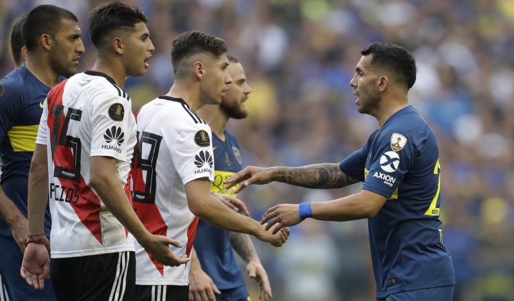 Carlos Tévez, de Boca Juniors, da la mano a Rafael Borre de River. /Foto: AP