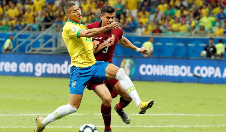El jugador de Brasil Richarlison (i) disputa el balón con Yordan Osorio de Venezuela. Foto:EFE