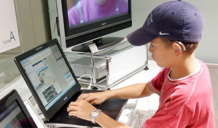 Un niño prueba un ordenador portátil .  EFE/Everett Kennedy Brown