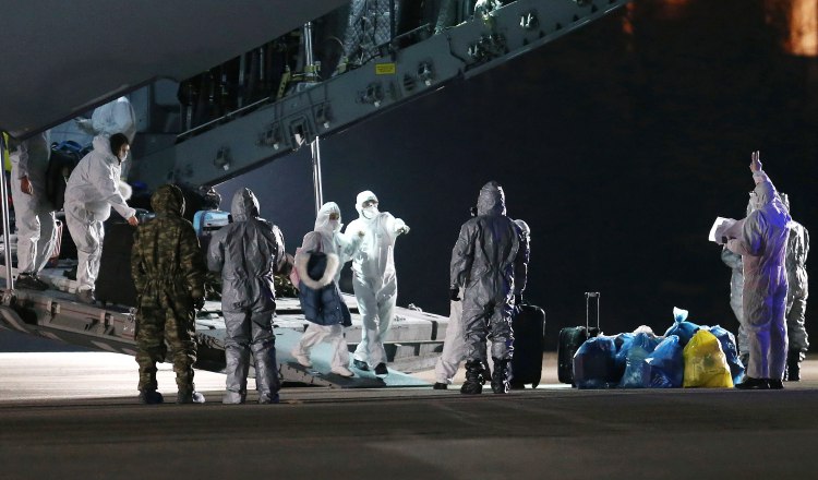 Especialistas bioquímicos recibieron ayer  en el aeropuerto de Ankara, a ciudadanos turcos evacuados de Wuhan, China. EFE.