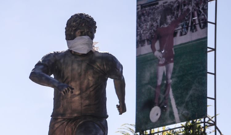 La estatua de Diego Armando Maradona luce un tapabocas.  EFE