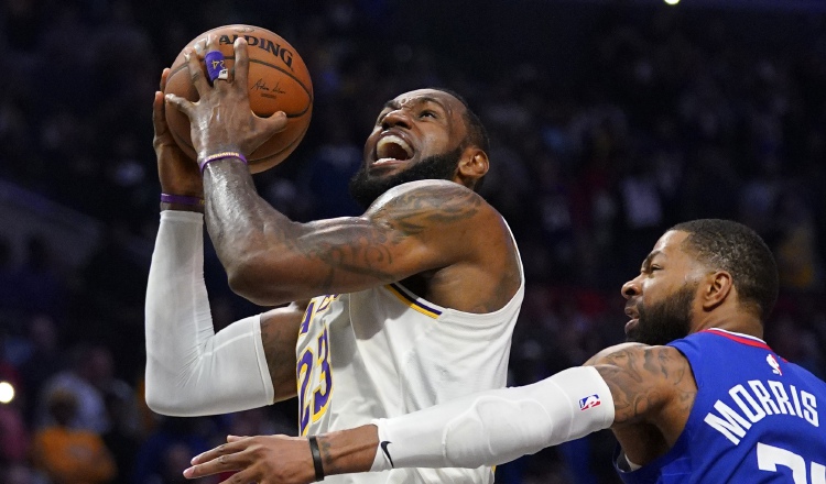 LeBron James de los Lakers es marcado por  Marcus Morris de los Clippers en un partido de la NBA. AP