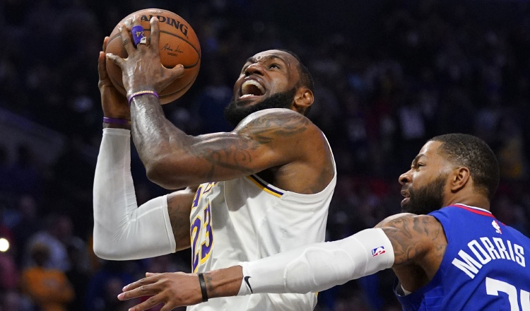 LeBron James (izq)de los Lakers anota una canasta ante Marcus Morris de losnClippers AP