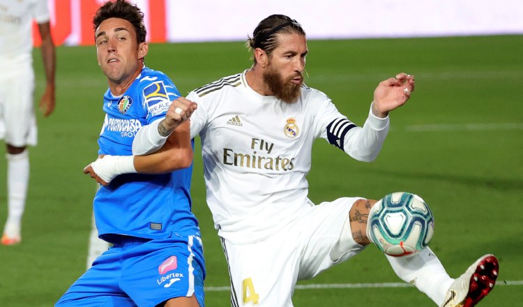 El defensa del Real Madrid, Sergio Ramos (der.) despeja el balón ante el delantero del Getafe, Jaime Mata. Foto:EFE