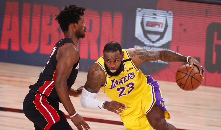 El alero de Lakers LeBron James (23) con el balón ante el alero del Miami Heat Jimmy Butler. Foto:EFE 