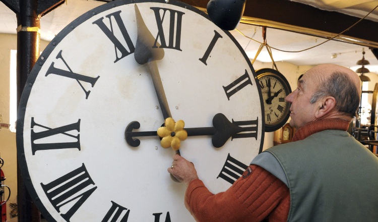 Peter Leonardy, examina un reloj fabricado alrededor del año 1900.