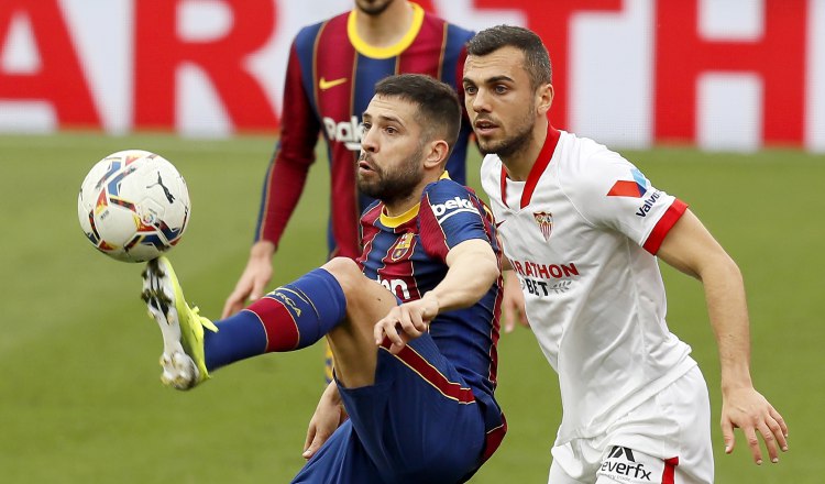 El defensa del Barcelona Jordi Alba (izq.) controla el balón ante el centrocampista del Sevilla Joan Jordán Foto:EFE