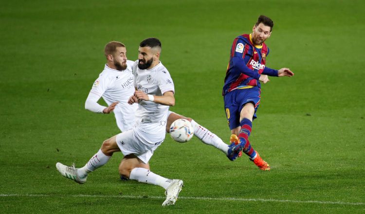 El delantero argentino del Barcelona, Leo Messi (der.) reamata el balón ante los defensores del Huesca. Foto:EFE