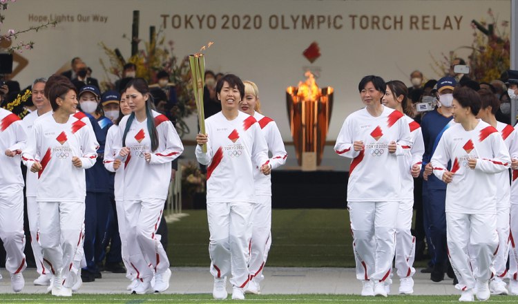 Azusa Iwashimizu (cent.) y otros miembros del equipo de fútbol femenino de Japón corren como portadores de la antorcha. Foto:EFE