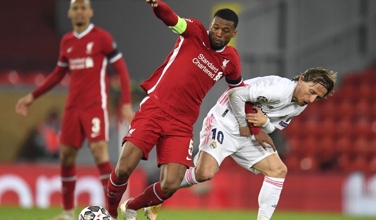 Georginio Wijnaldum del Liverpol es sujetado por  Luka Modric del Real Madrid. Foto:EFE