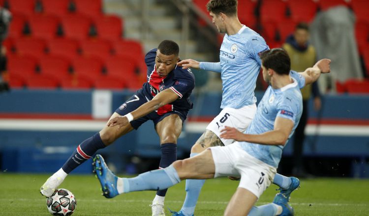 Kylian Mbappé del PSG intenta dominar el balón ante la marca de dos jugadores del Manchester City. Foto:EFE