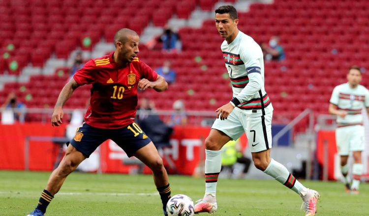 Thiago Alcántara (izq.) de España y Cristiano Ronaldo de Portugal, disputan un balón Foto:EFE
