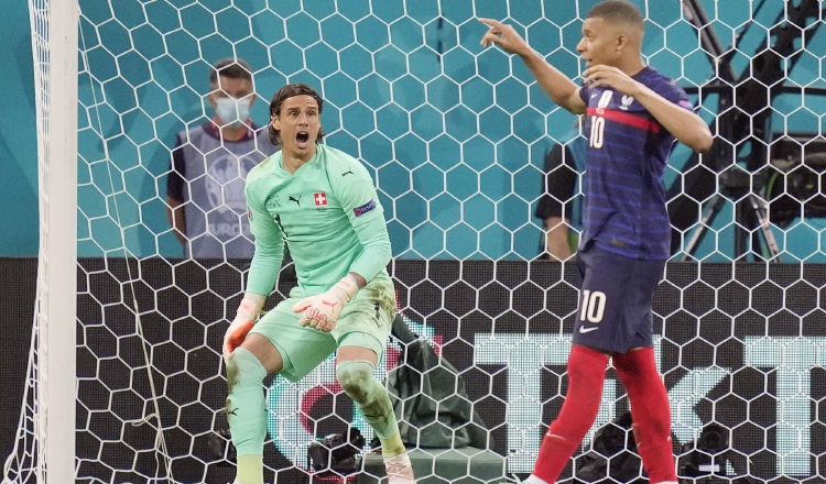 El portero de Suiza, Yann Sommer, festeja, mientras que el francés  Kylian Mbappé lamenta fallar su tiro penal. Foto:EFE