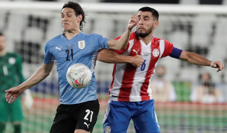 Edinson Cavani (izq.) de Uruguay disputa el balón con Junior Alonso de Paraguay. Foto:EFE