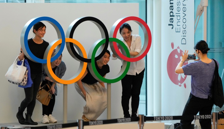 Aficionados se toman fotos con los anillos olímpicos. Foto:EFE