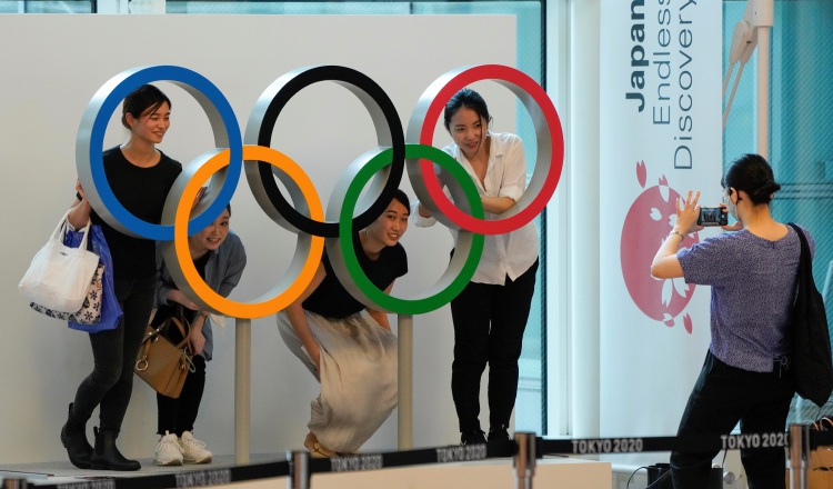 Aficionados posan con la argollas olímpicas en Tokio. Foto:EFE