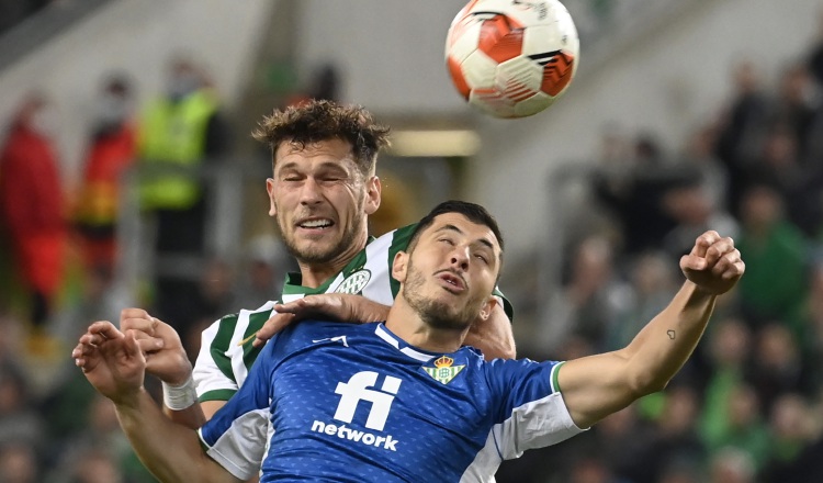 Guido Rodríguez del Real Betis (frente) salta a disputar el balón contra Balint Vecsei de Ferencvaros. Foto:EFE