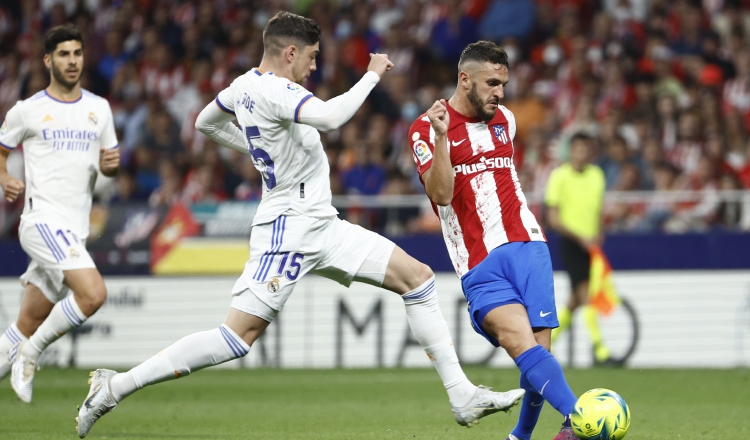 Koke (der.) golpea el balón ante Fede Valverde del Real Madrid. Foto:EFE