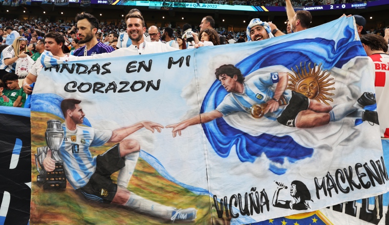 2- Aficionados de Argentina con una imagen de Maradona y Leo Messi