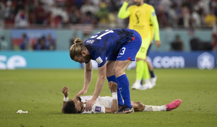 Tim Ream de Estados Unidos (azul) intenta consolar y levantar a Ramin Rezaeian de Irán Foto:EFE