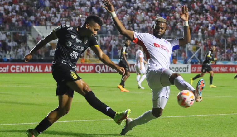 Sergio Ramírez del CAI (izq.), despeja el balón ante la llegada de Jorge Benguché del Olimpia. Foto:EFE