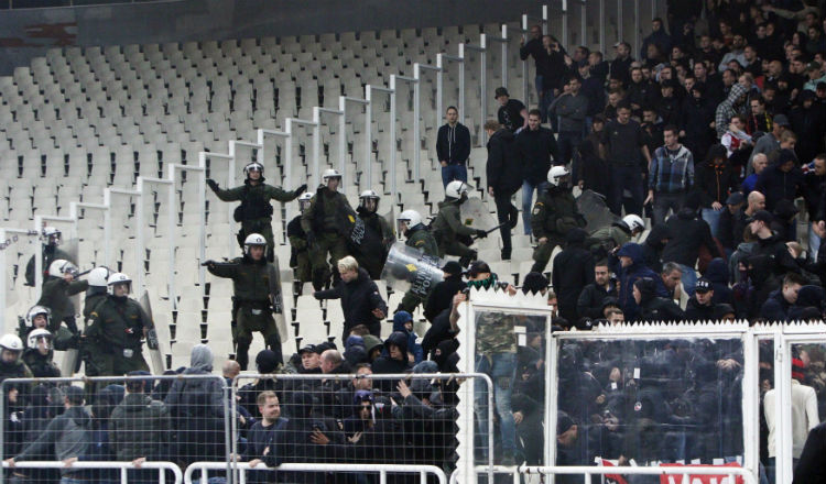 Policías griegos tratan de controlar a aficionados de Ajax. Foto EFE