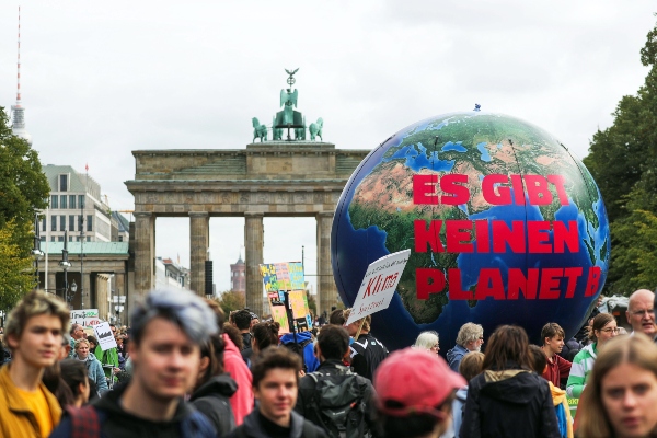 Decenas de jóvenes manifestantes sostienen un globo gigante con la inscripción