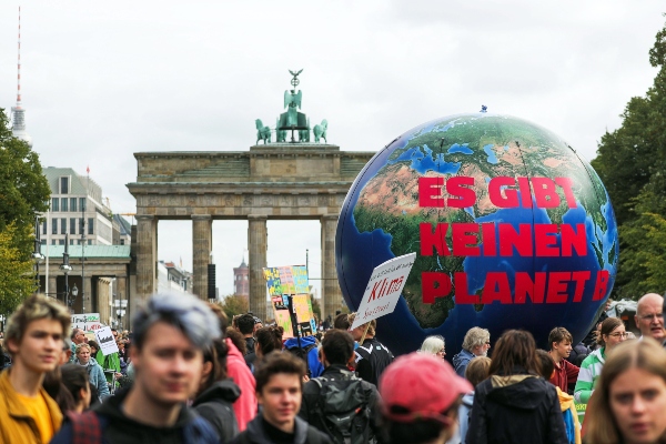  Decenas de jóvenes manifestantes sostienen un globo gigante con la inscripción 