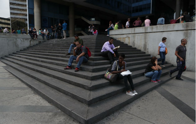  Venezolanos permanecen a la entrada de un edificio durante el apagón eléctrico en Caracas (Venezuela). Foto: EFE.