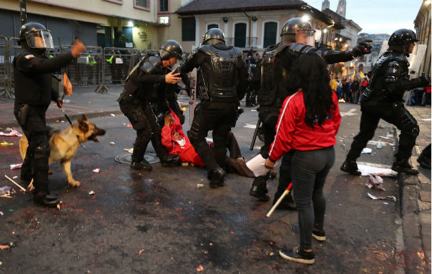  Policías se enfrentan a manifestantes durante una protesta de apoyo a favor del australiano Julian Assange, en Quito. Foto: EFE.