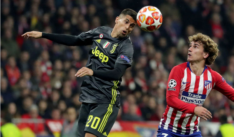 El defensa de la Juventus, Joao Pedro Cancelo (izq.) cabecea el balón ante el delantero del Atlético de Madrid, Antoine Griezmann. Foto:EFE