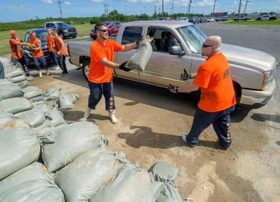 Los trabajadores internos de la Oficina del Alguacil de la Parroquia de St. Bernard trasladan sacos de arena gratuitos para los residentes de Chalmette. FOTO/AP