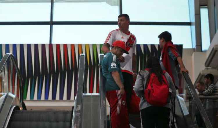 Hinchas del Boca Juniors y River Plate esperan en el Aeropuerto Internacional de Ezeiza para viajar a Madrid. Foto EFE