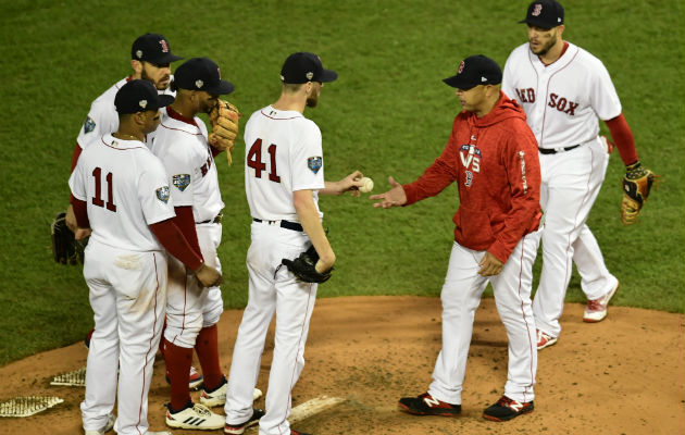 El lanzador de los Medias Rojas Chris Sale (cent.) entrega la pelota el entrenador Alex Cora (rojo). Foto:EFE