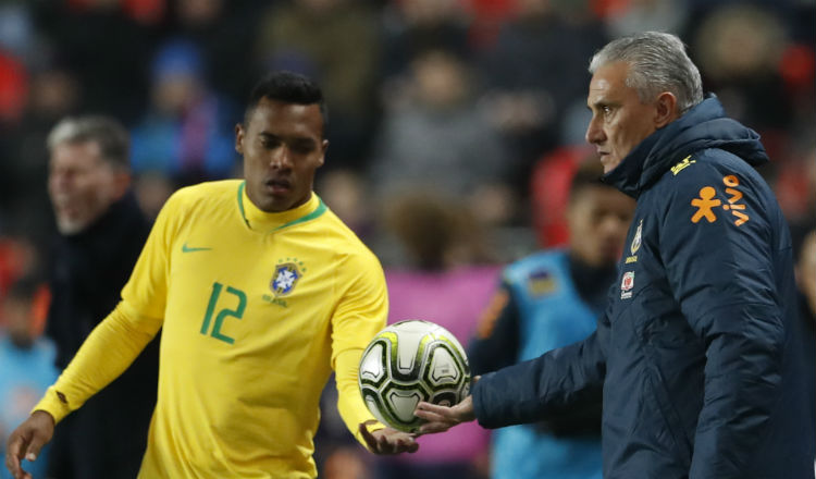 Tite entrega el balón a un jugador de la selección de Brasil. Foto AP