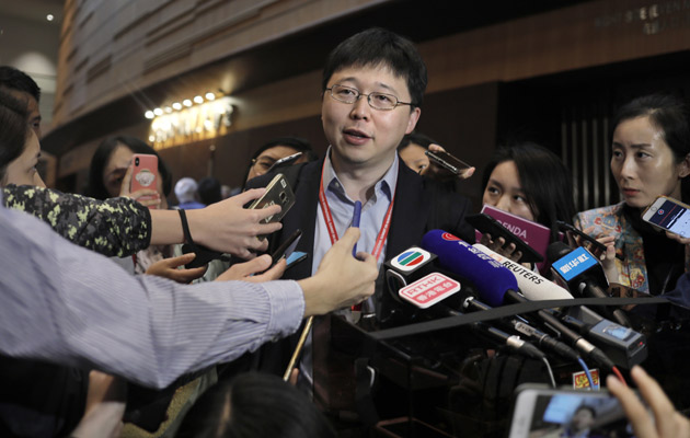 Feng Zhang, centro, miembro del instituto de Harvard y del Instituto Broad del MIT, reacciona ante los reporteros sobre el tema de los primeros bebés modificados genéticamente. FOTO/AP