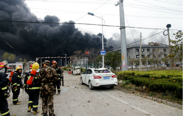 Bomberos en las afueras de la fábrica siniestrada. Foto: AP.