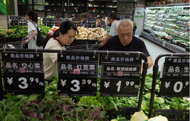 Compradores seleccionan verduras en un supermercado en Pekín (China). Foto: EFE.