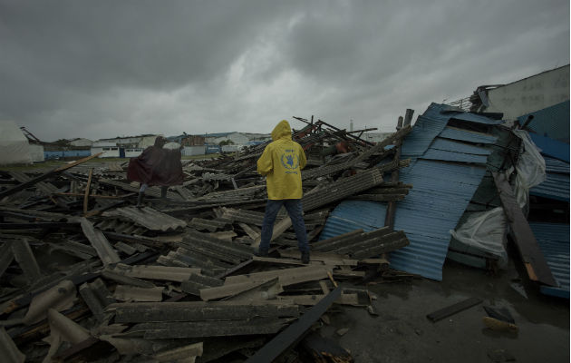 Un hombre camina sobre viviendas destruidas por el ciclón Idai en Beira, provincia Sofala en Mozambique.  Foto: AP 