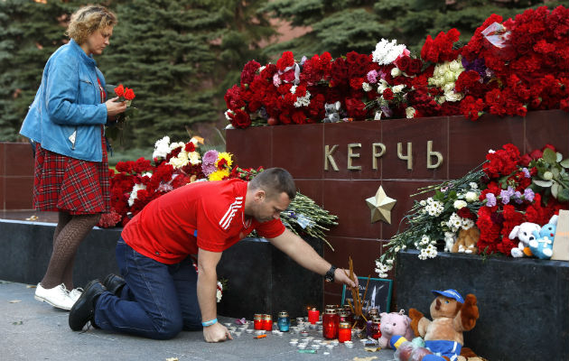 La gente trae flores y velas para honrar a las víctimas del ataque del miércoles a una escuela vocacional en Kerch, Crimea. AP