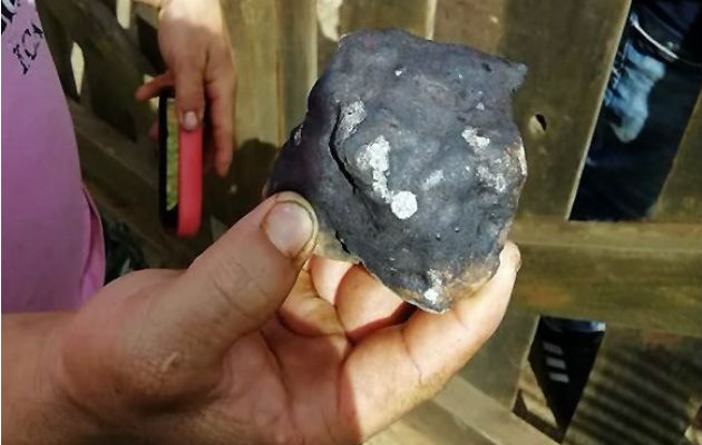 Una persona muestra restos del meteorito caído. Foto: AP.