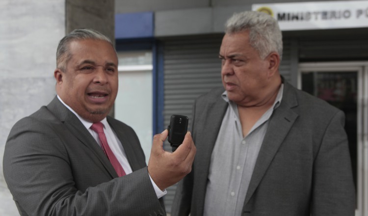 El abogado Roiniel Ortiz muestra el dispositivo que fue encontrado en el automóvil del jurista Alejandro Pérez. 