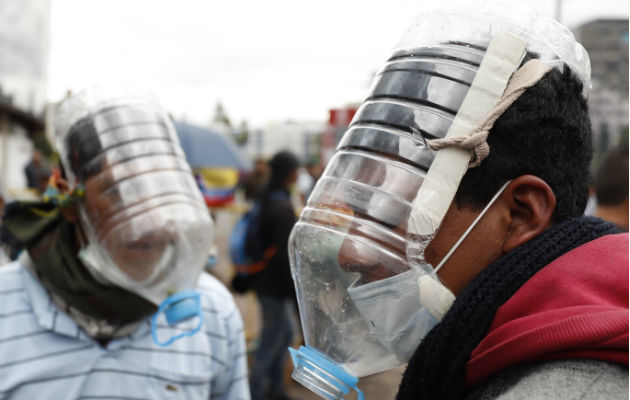 Manifestantes usan máscaras antigas elaboradas por el ecuatoriano Cesar Viteri este jueves en Quito.  Foto: EFE.