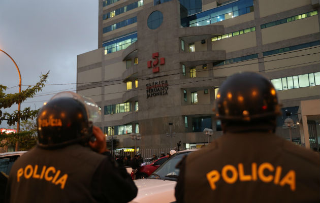 Integrantes de la policía en Perú vigilan afuera de la clínica. Foto: EFE