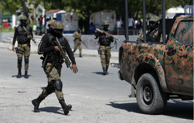 Guardias presidenciales custodian un convoy que transporta al presidente Jovenel Moise. Foto. AP.