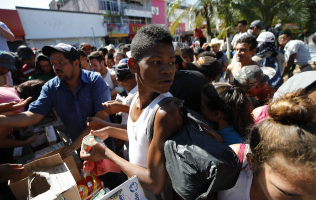 Migrantes hondureños reciben comestibles y se preparan para continuar su camino. EFE